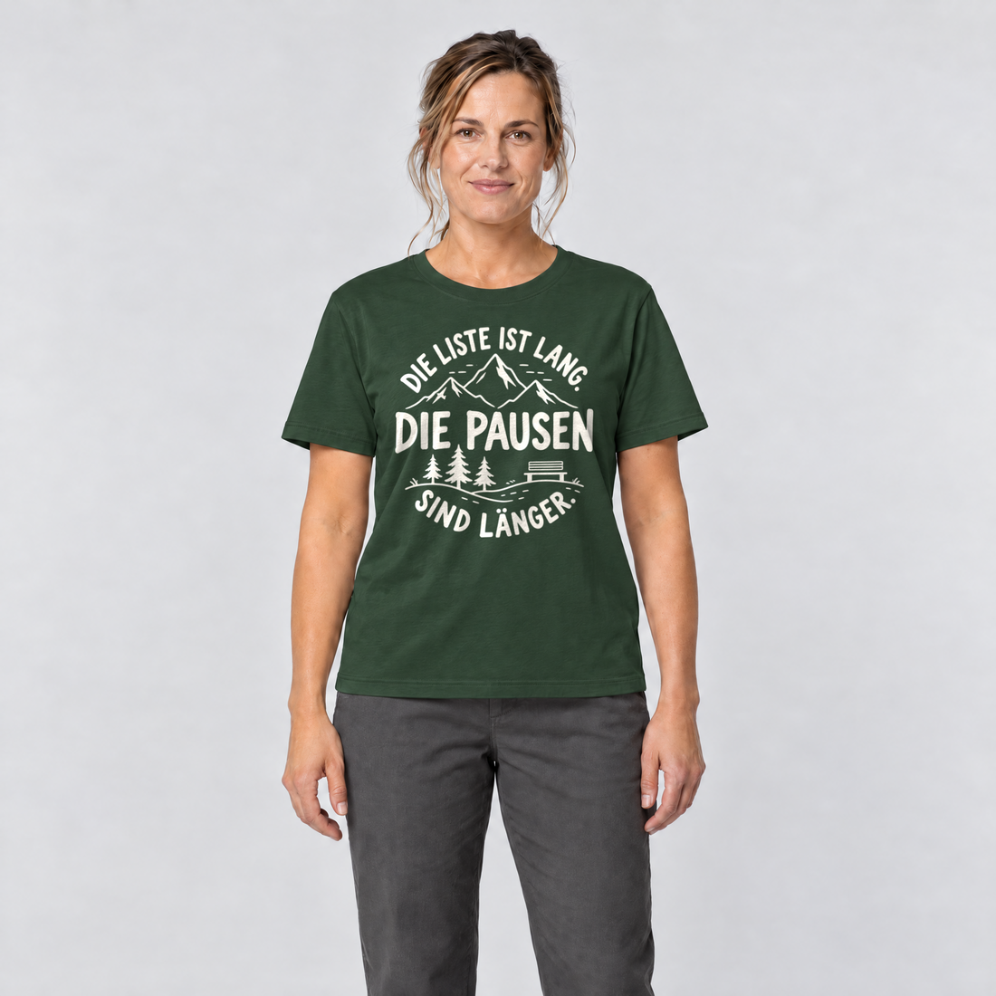Frau trägt Die Pausen sind länger – T-Shirt Unisex in Flaschengrün, Ansicht von vorn