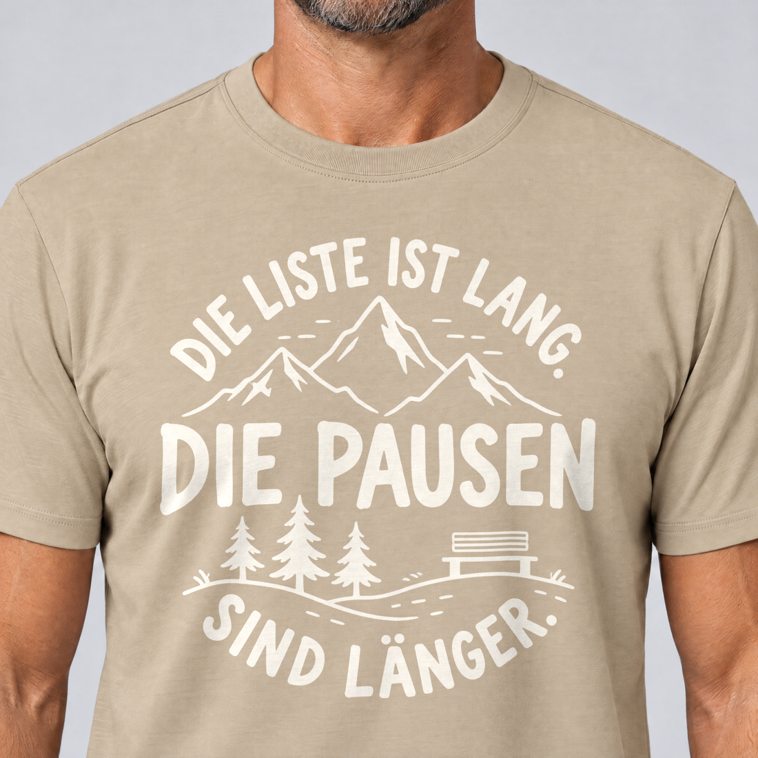 Nahaufnahme des Drucks: Die Pausen sind länger – T-Shirt Unisex in Sand, von einem Mann getragen