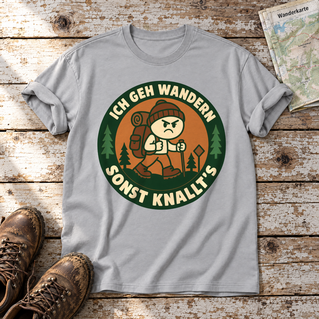 Sonst knallt’s – T-Shirt Unisex in Hellgrau, flach liegend auf alten Holzbrettern mit Wanderschuhen und Wanderkarte.