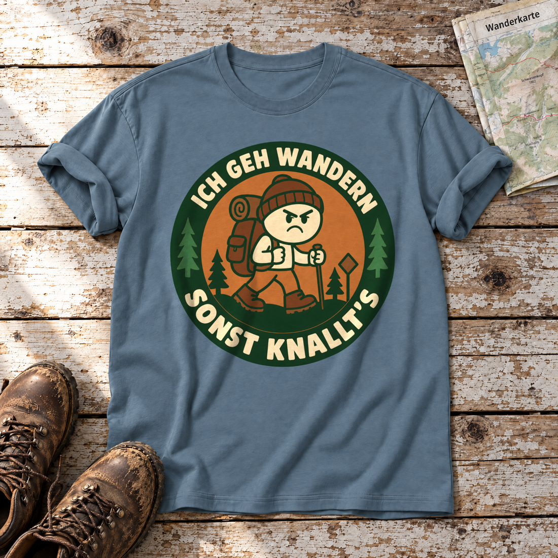 Sonst knallt’s – T-Shirt Unisex in Steinblau, flach liegend auf alten Holzbrettern mit Wanderschuhen und Wanderkarte.