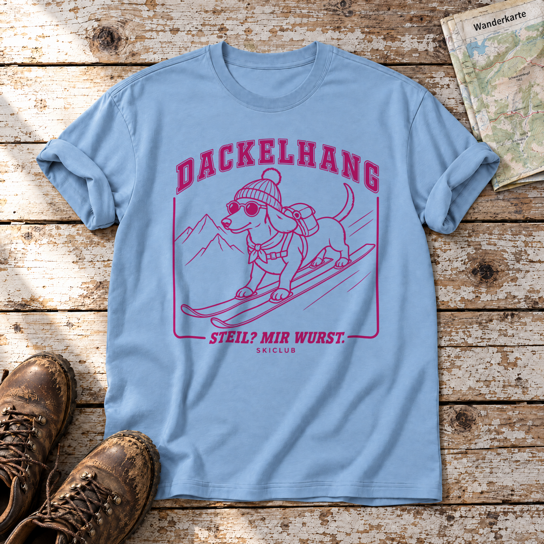 Steil? Mir Wurst. – T-Shirt Unisex in Himmelblau, flach liegend auf alten Holzbrettern mit Wanderschuhen und Wanderkarte.