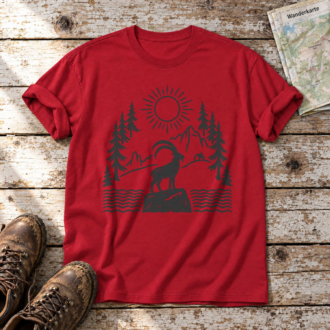 Steinbock am Bergsee – T-Shirt Unisex in Rot, flach liegend auf alten Holzbrettern mit Wanderschuhen und Wanderkarte.