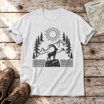 Steinbock am Bergsee – T-Shirt Unisex in Weiß, flach liegend auf alten Holzbrettern mit Wanderschuhen und Wanderkarte.
