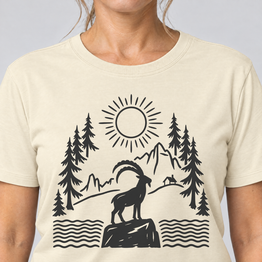 Nahaufnahme des Drucks: Steinbock am Bergsee – T-Shirt Unisex in Natur, von einer Frau getragen