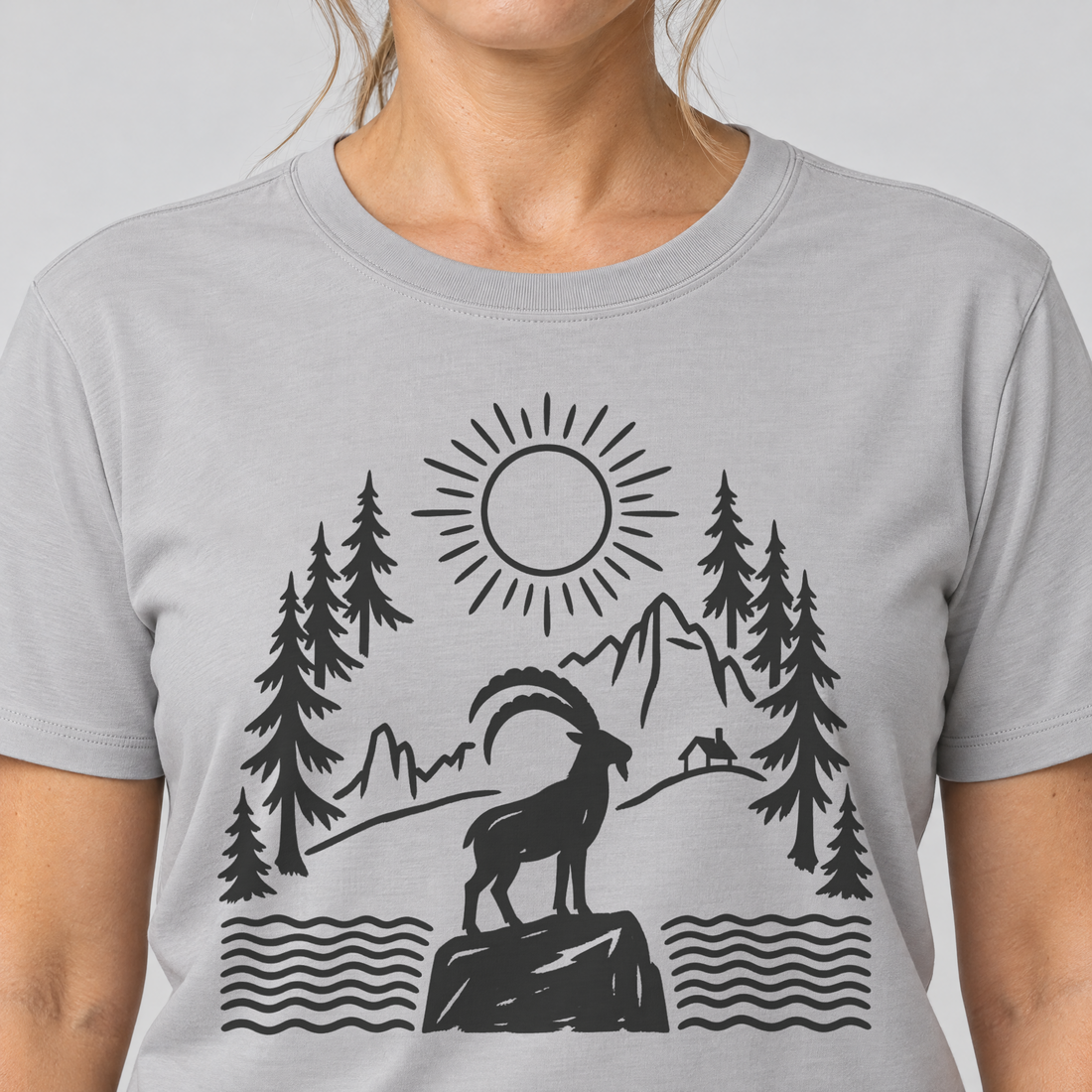 Nahaufnahme des Drucks: Steinbock am Bergsee – T-Shirt Unisex in Hellgrau, von einer Frau getragen