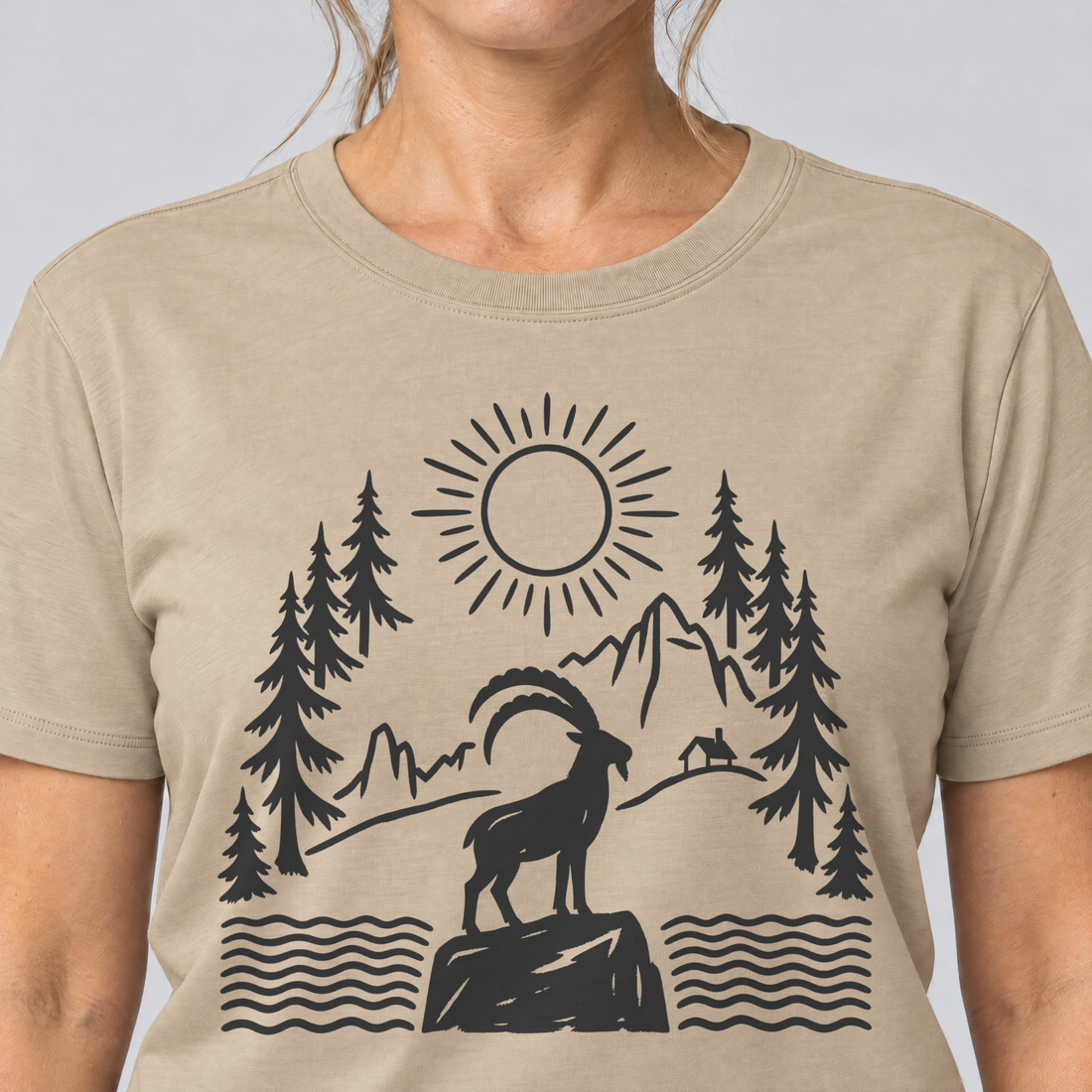 Nahaufnahme des Drucks: Steinbock am Bergsee – T-Shirt Unisex in Sand, von einer Frau getragen