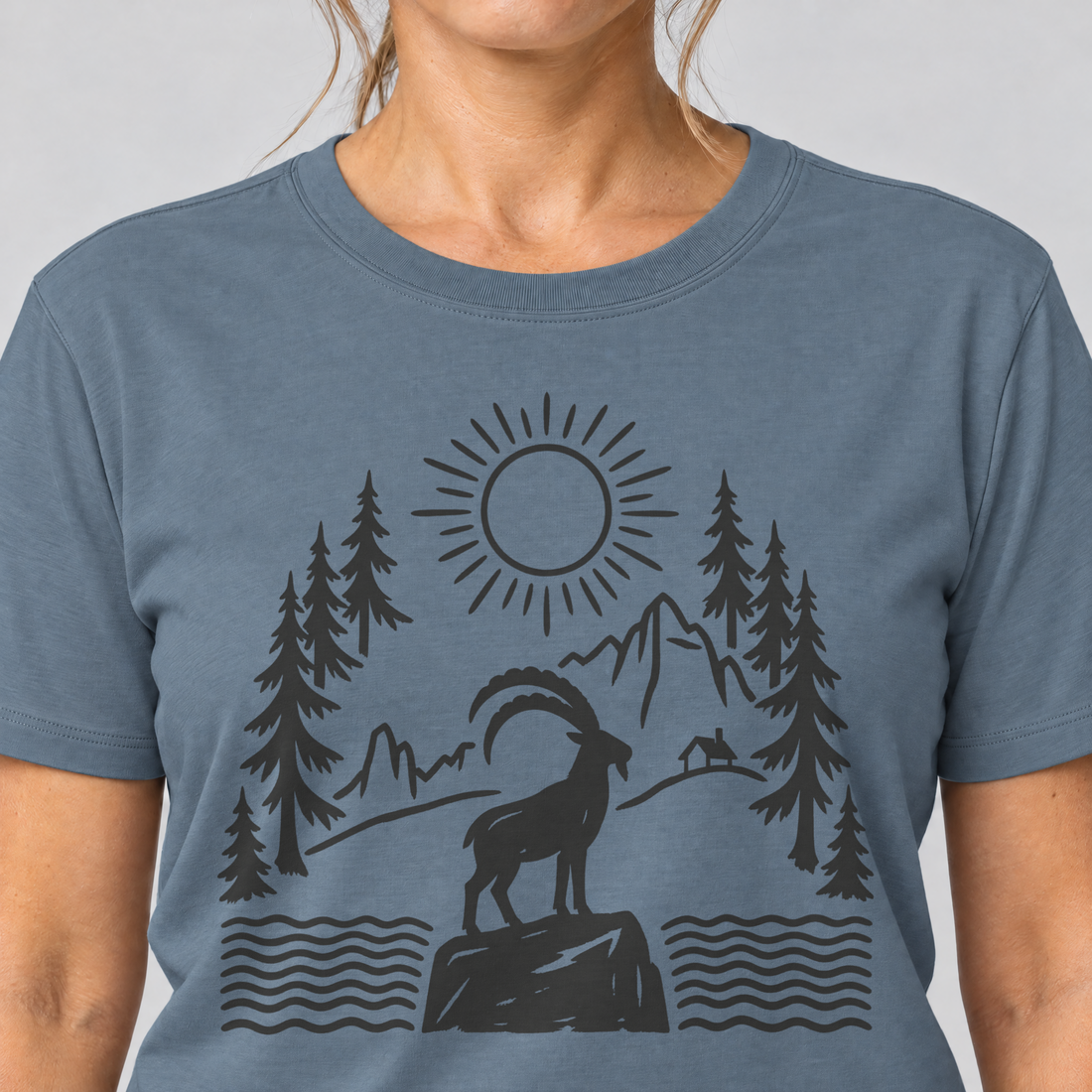 Nahaufnahme des Drucks: Steinbock am Bergsee – T-Shirt Unisex in Steinblau, von einer Frau getragen