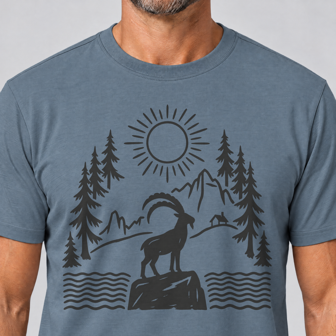 Nahaufnahme des Drucks: Steinbock am Bergsee – T-Shirt Unisex in Steinblau, von einem Mann getragen