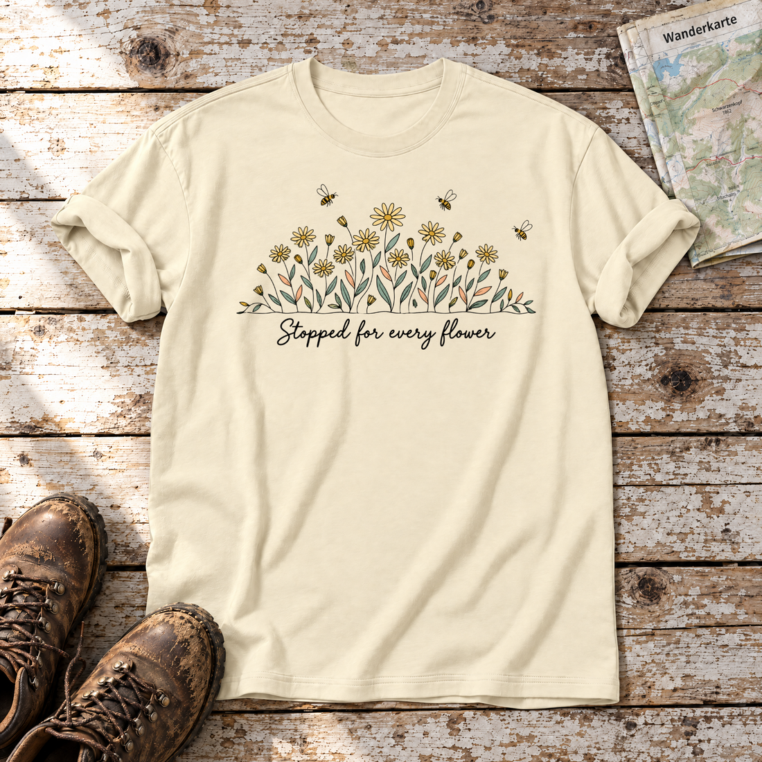 Stopped for every flower – T-Shirt Unisex in Natur, flach liegend auf alten Holzbrettern mit Wanderschuhen und Wanderkarte.