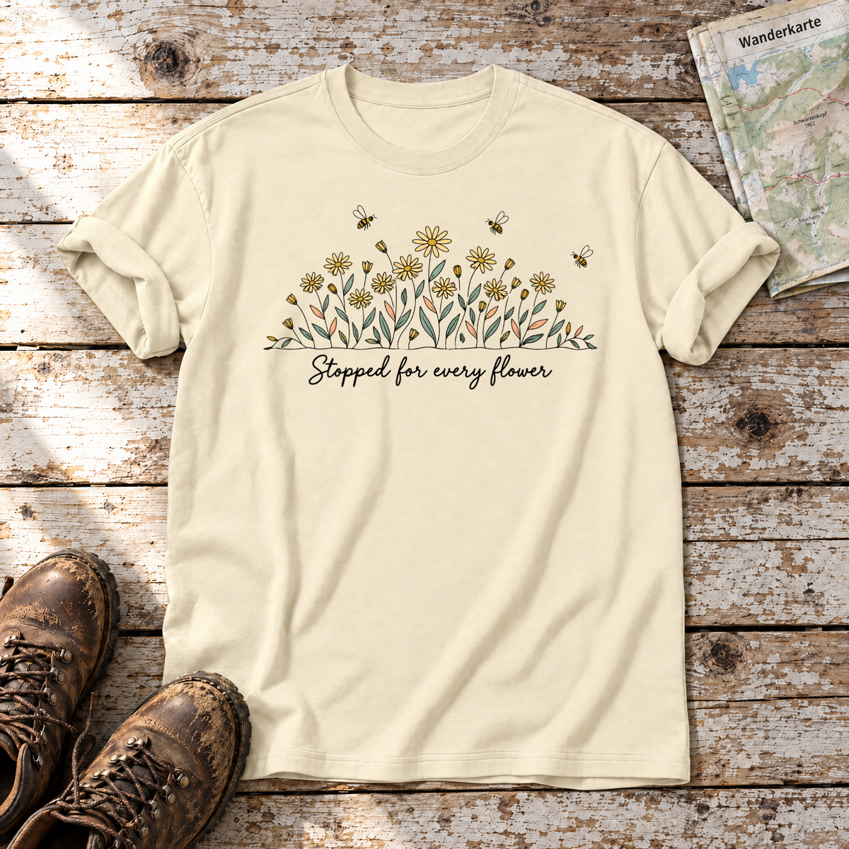 Stopped for every flower – T-Shirt Unisex in Natur, flach liegend auf alten Holzbrettern mit Wanderschuhen und Wanderkarte.