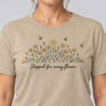 Nahaufnahme des Drucks: Stopped for every flower – T-Shirt Unisex in Sand, von einer Frau getragen