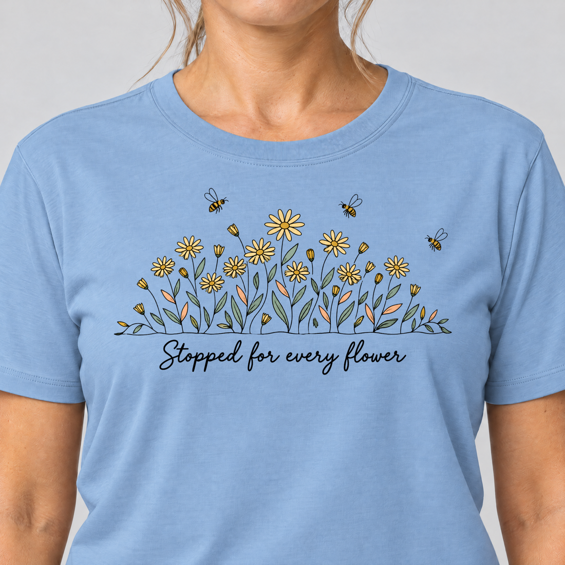 Nahaufnahme des Drucks: Stopped for every flower – T-Shirt Unisex in Himmelblau, von einer Frau getragen