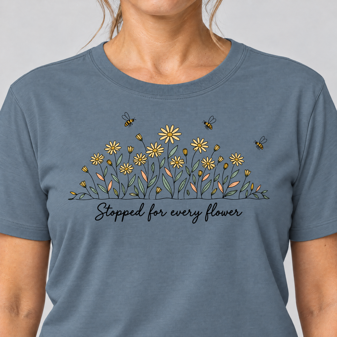 Nahaufnahme des Drucks: Stopped for every flower – T-Shirt Unisex in Steinblau, von einer Frau getragen