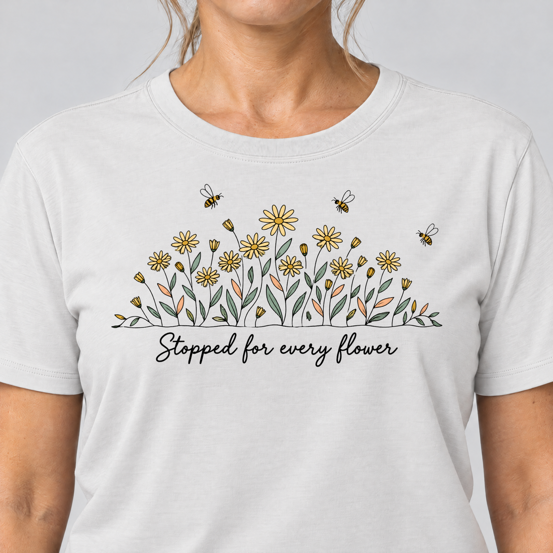 Nahaufnahme des Drucks: Stopped for every flower – T-Shirt Unisex in Weiß, von einer Frau getragen