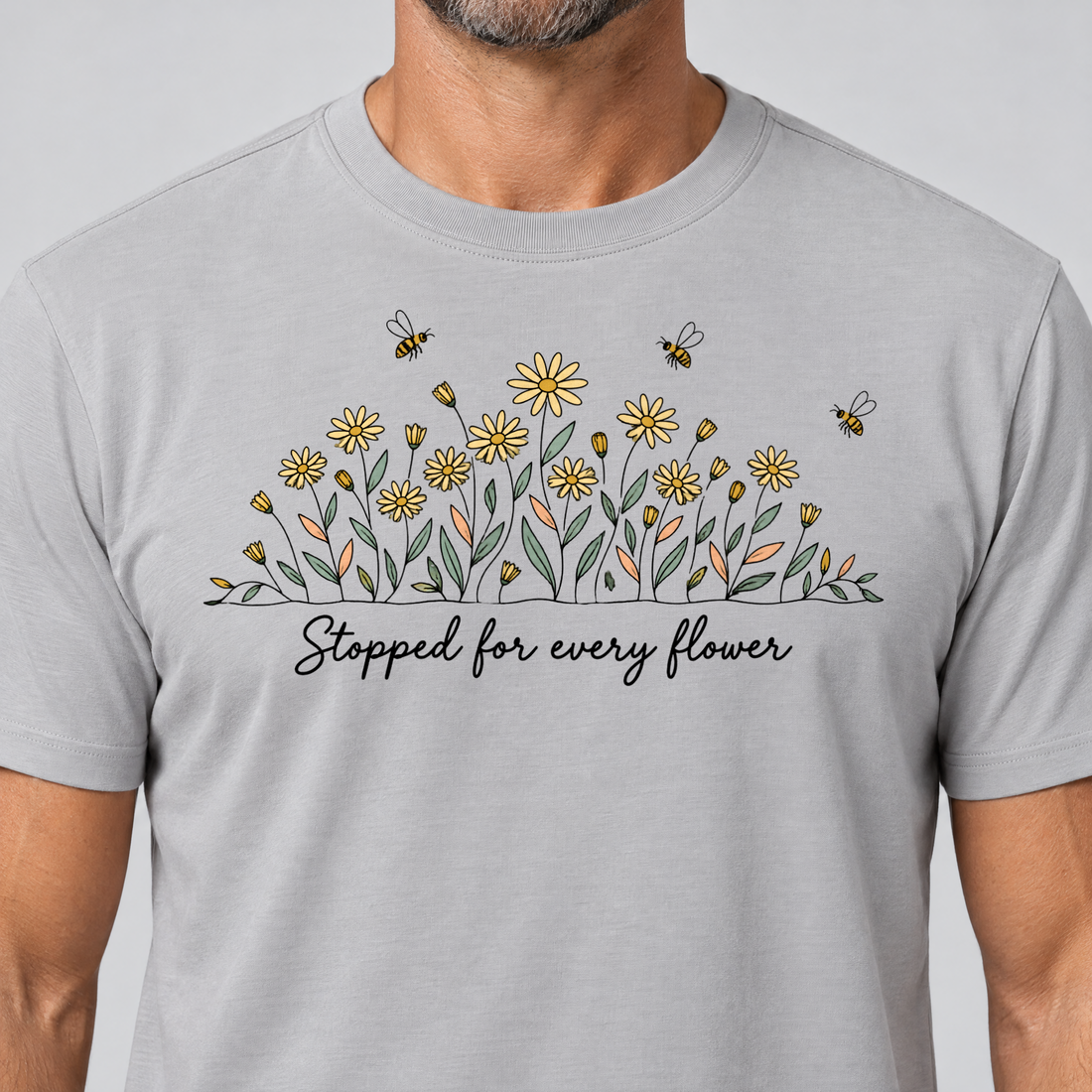 Nahaufnahme des Drucks: Stopped for every flower – T-Shirt Unisex in Hellgrau, von einem Mann getragen