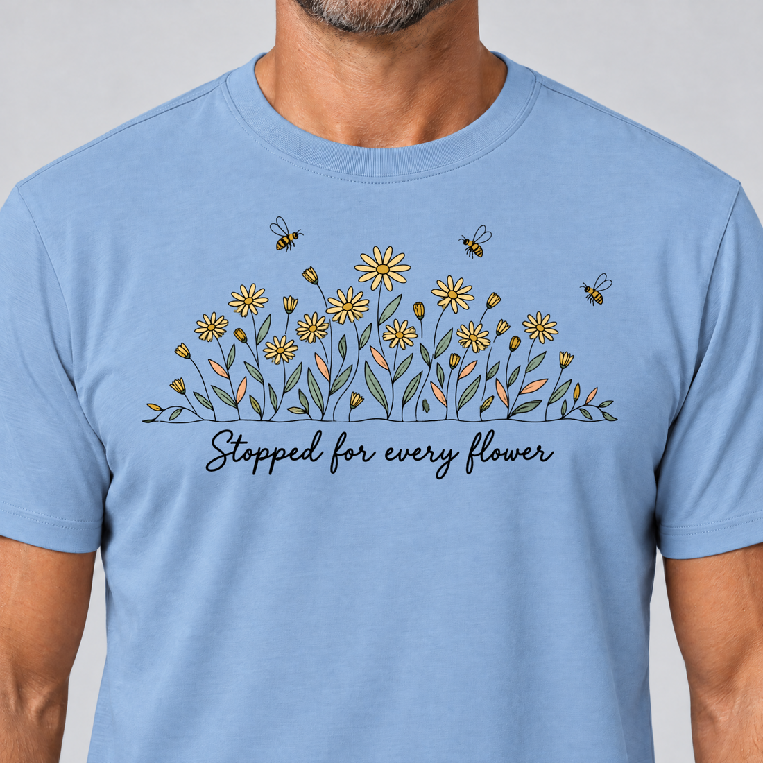Nahaufnahme des Drucks: Stopped for every flower – T-Shirt Unisex in Himmelblau, von einem Mann getragen