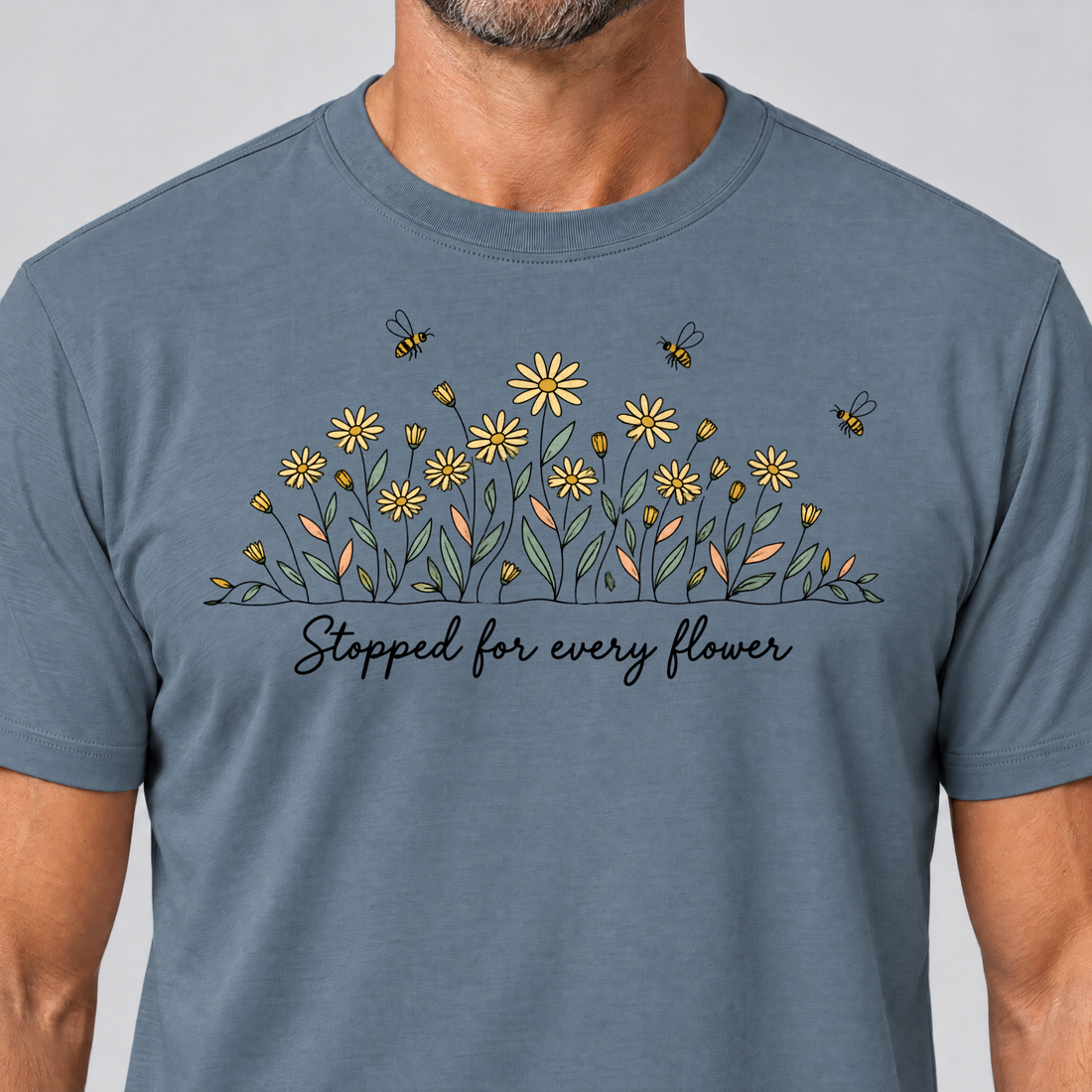 Nahaufnahme des Drucks: Stopped for every flower – T-Shirt Unisex in Steinblau, von einem Mann getragen