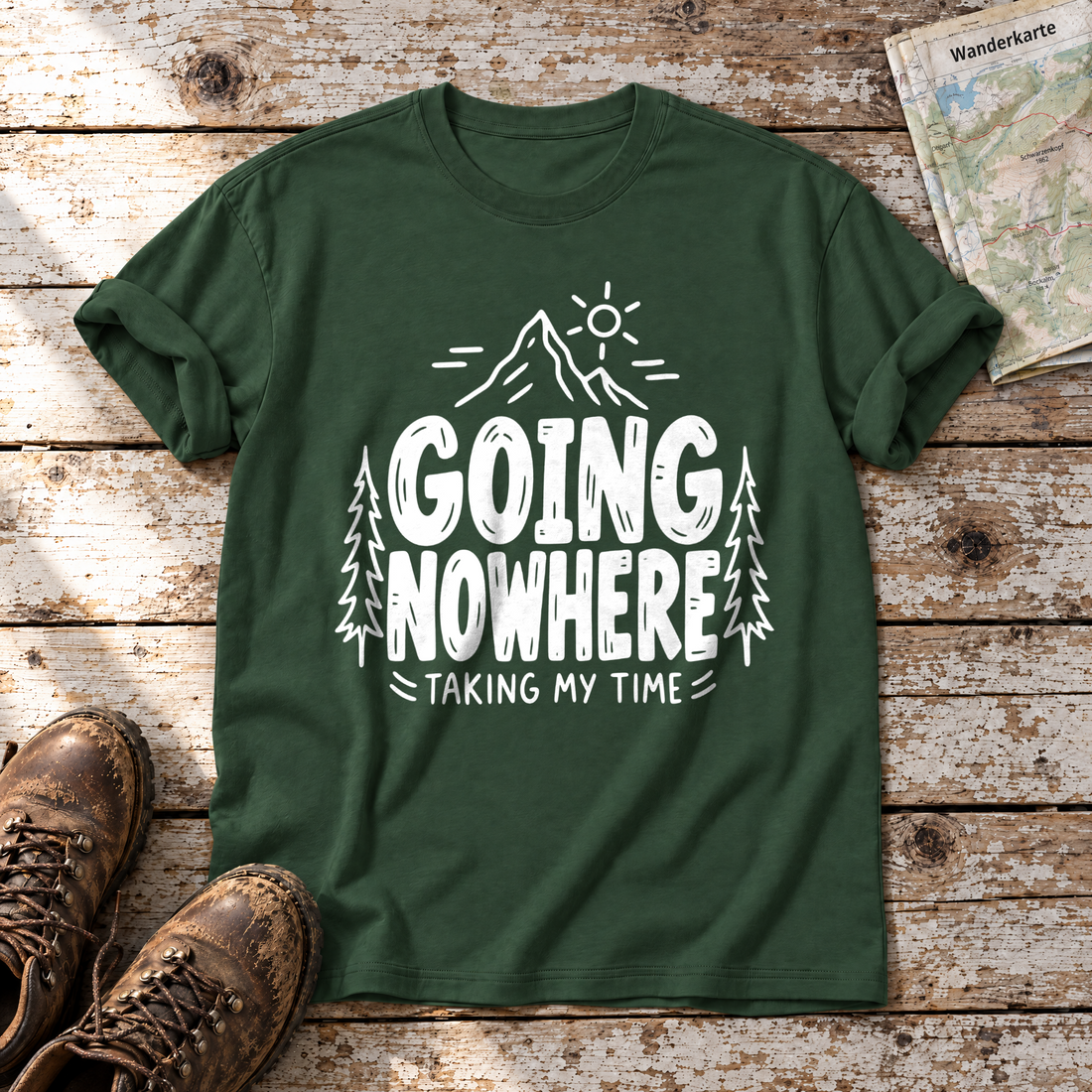 Going Nowhere – T-Shirt Unisex in Flaschengrün, flach liegend auf alten Holzbrettern mit Wanderschuhen und Wanderkarte.