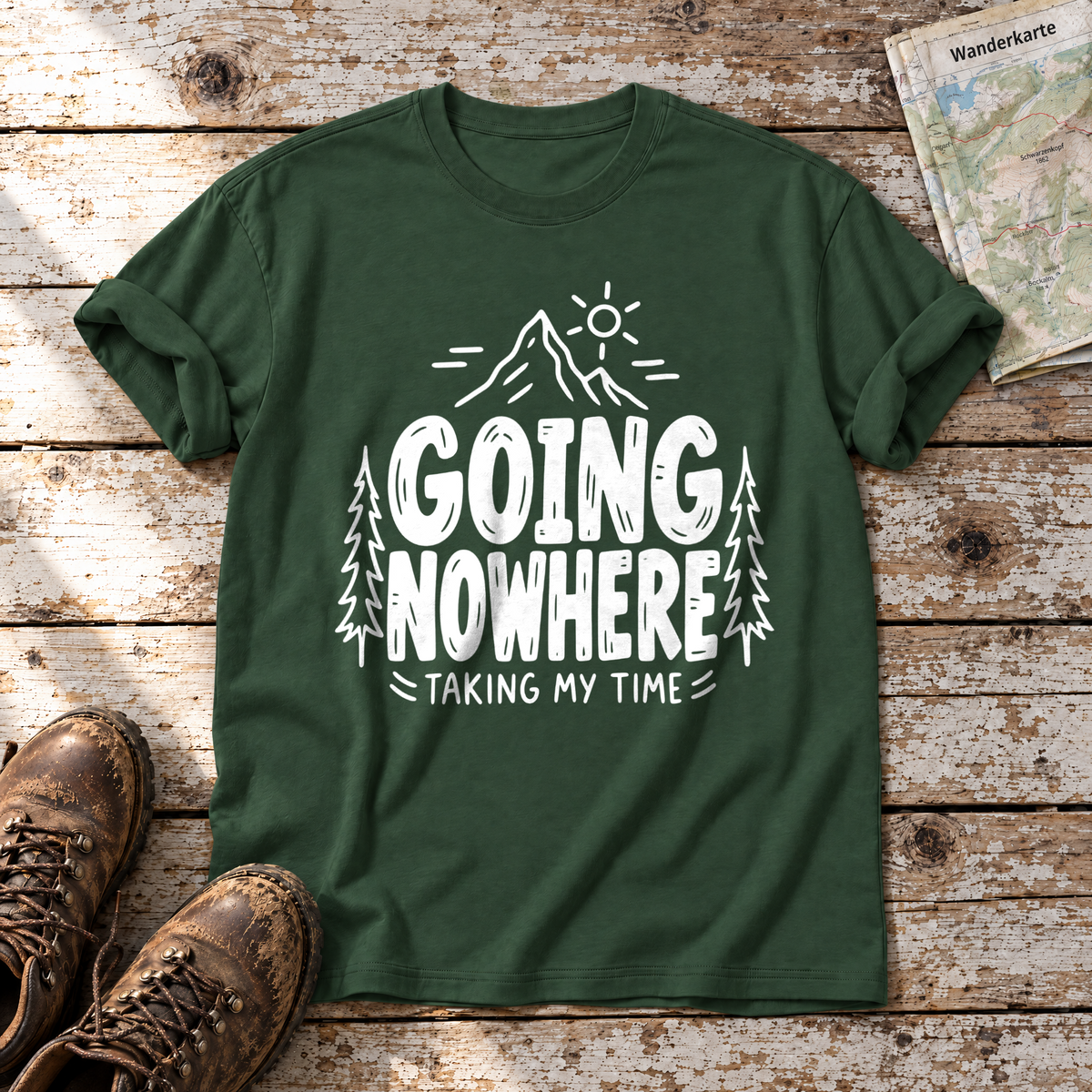 Going Nowhere – T-Shirt Unisex in Flaschengrün, flach liegend auf alten Holzbrettern mit Wanderschuhen und Wanderkarte.