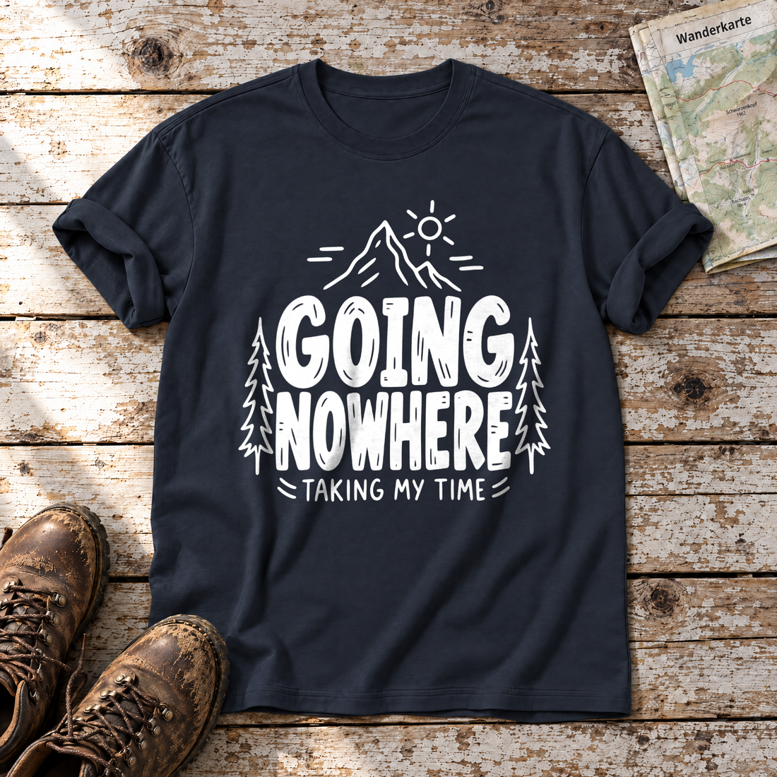 Going Nowhere – T-Shirt Unisex in Navy, flach liegend auf alten Holzbrettern mit Wanderschuhen und Wanderkarte.