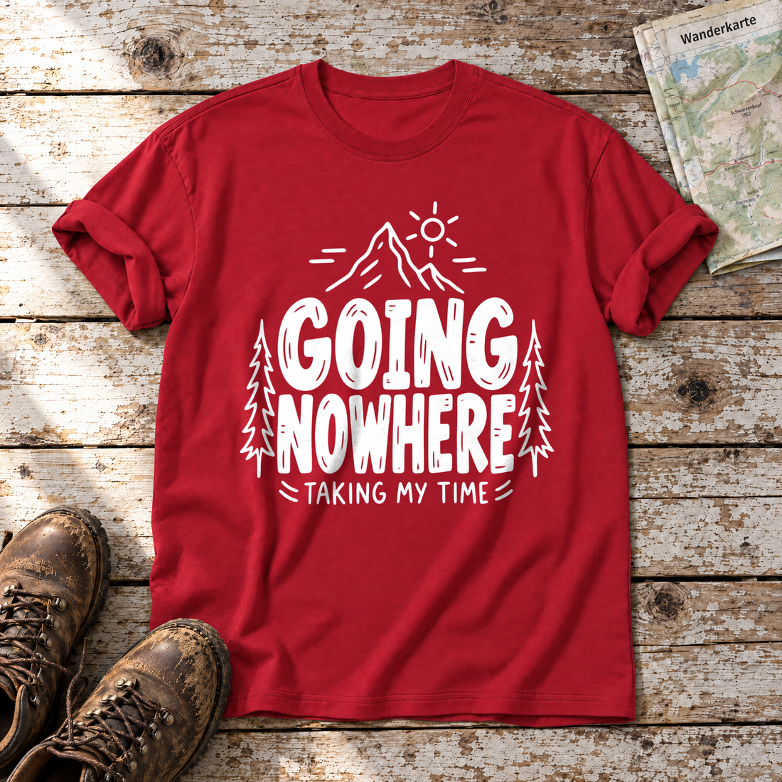 Going Nowhere – T-Shirt Unisex in Rot, flach liegend auf alten Holzbrettern mit Wanderschuhen und Wanderkarte.