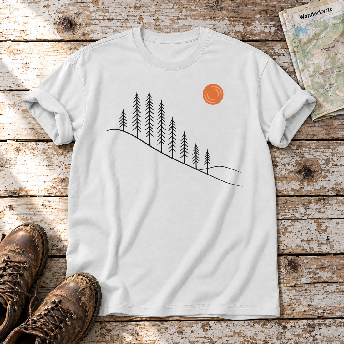 Tannenhang – T-Shirt Unisex in Weiß, flach liegend auf alten Holzbrettern mit Wanderschuhen und Wanderkarte.