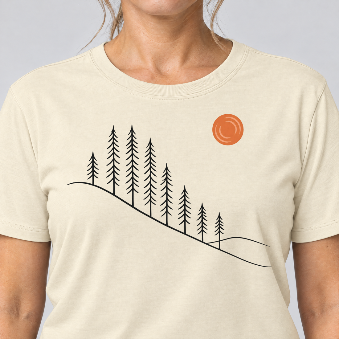 Nahaufnahme des Drucks: Tannenhang – T-Shirt Unisex in Natur, von einer Frau getragen
