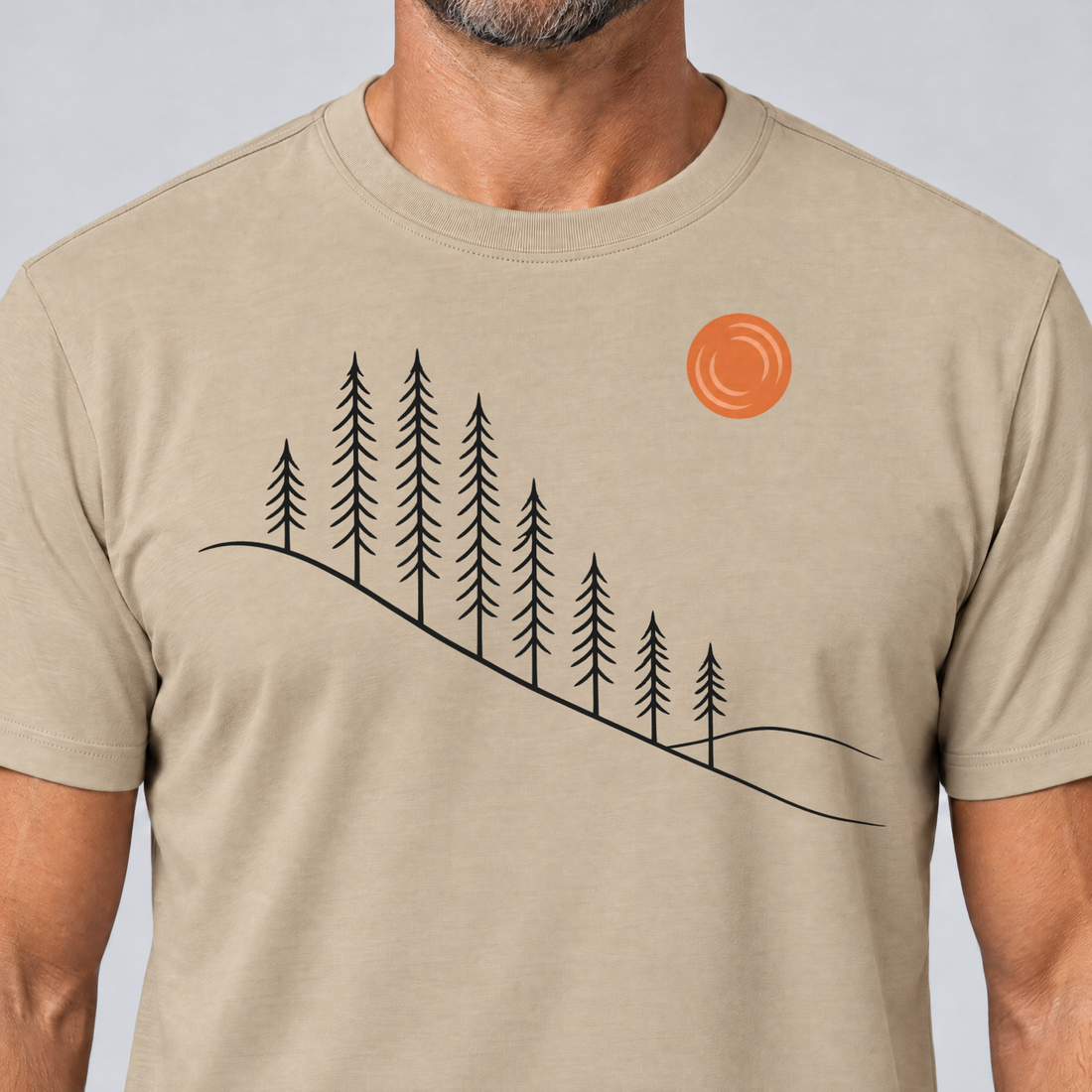 Nahaufnahme des Drucks: Tannenhang – T-Shirt Unisex in Sand, von einem Mann getragen