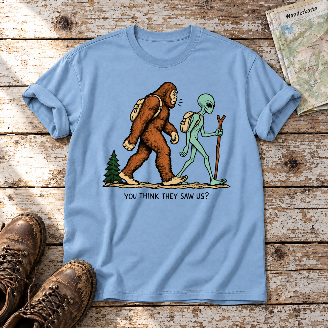 Think they saw us? – T-Shirt Unisex in Himmelblau, flach liegend auf alten Holzbrettern mit Wanderschuhen und Wanderkarte.