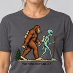 Nahaufnahme des Drucks: Think they saw us? – T-Shirt Unisex in Dunkelgrau, von einer Frau getragen