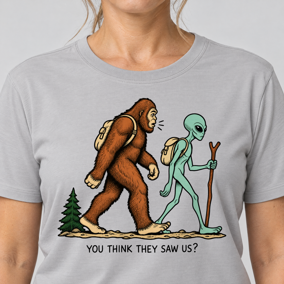 Nahaufnahme des Drucks: Think they saw us? – T-Shirt Unisex in Hellgrau, von einer Frau getragen