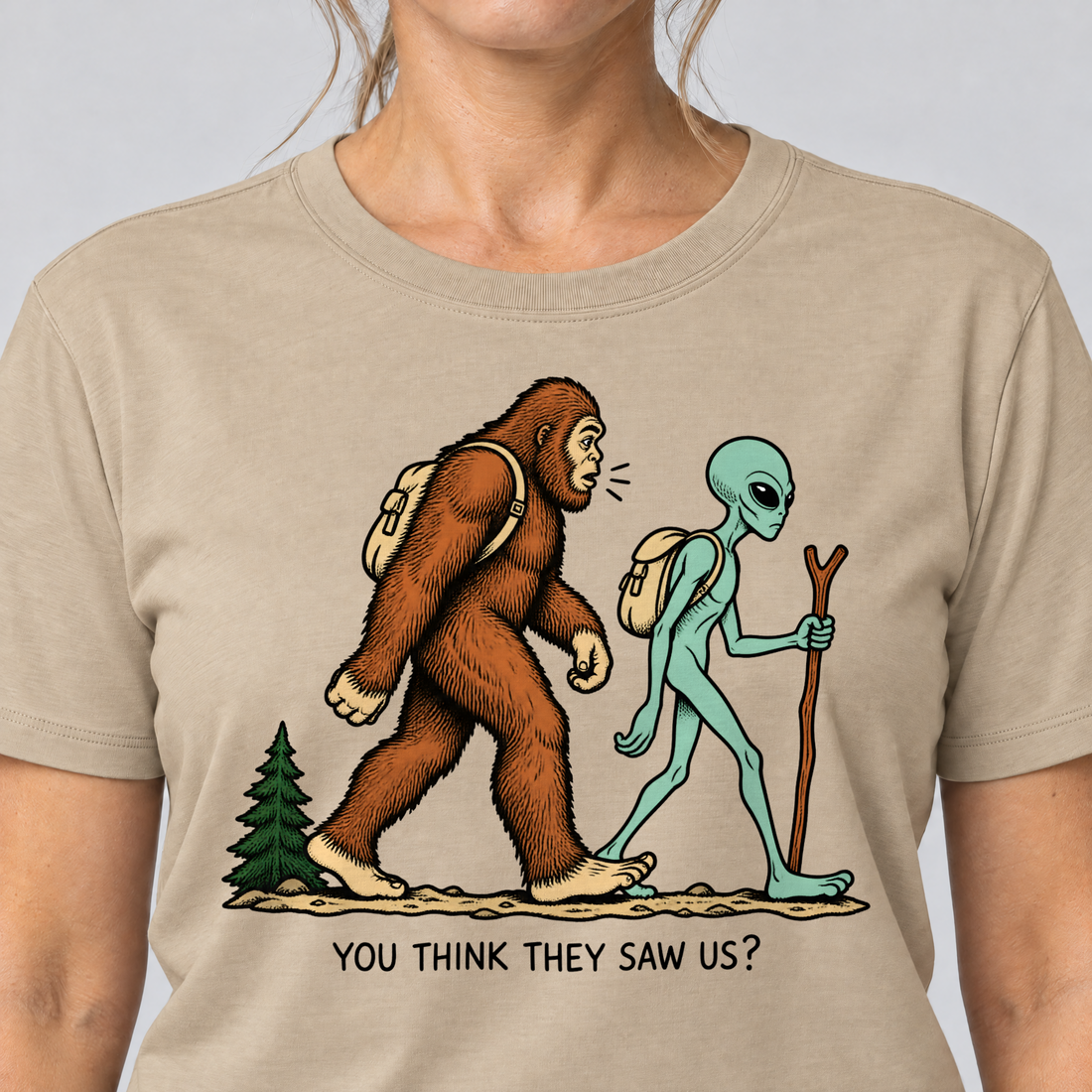 Nahaufnahme des Drucks: Think they saw us? – T-Shirt Unisex in Sand, von einer Frau getragen