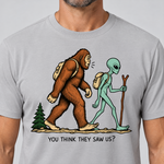 Nahaufnahme des Drucks: Think they saw us? – T-Shirt Unisex in Hellgrau, von einem Mann getragen