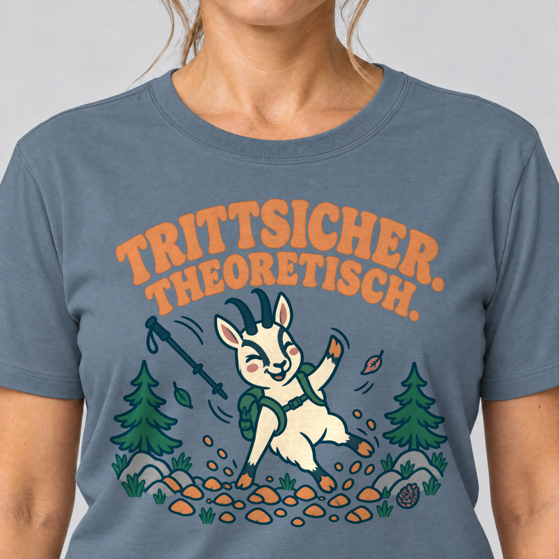 Nahaufnahme des Drucks: Trittsicher. Theoretisch. – T-Shirt Unisex in Steinblau, von einer Frau getragen