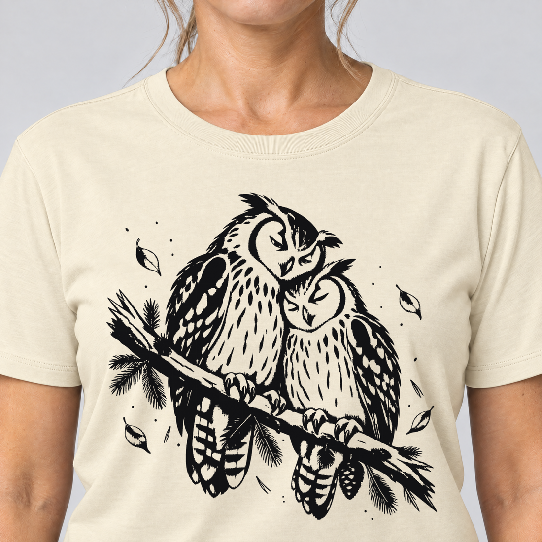 Nahaufnahme des Drucks: Uhupaar auf dem Fichtenast – T-Shirt Unisex in Natur, von einer Frau getragen