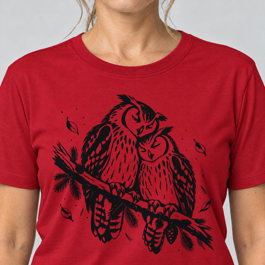 Nahaufnahme des Drucks: Uhupaar auf dem Fichtenast – T-Shirt Unisex in Rot, von einer Frau getragen