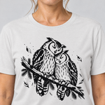 Nahaufnahme des Drucks: Uhupaar auf dem Fichtenast – T-Shirt Unisex in Weiß, von einer Frau getragen