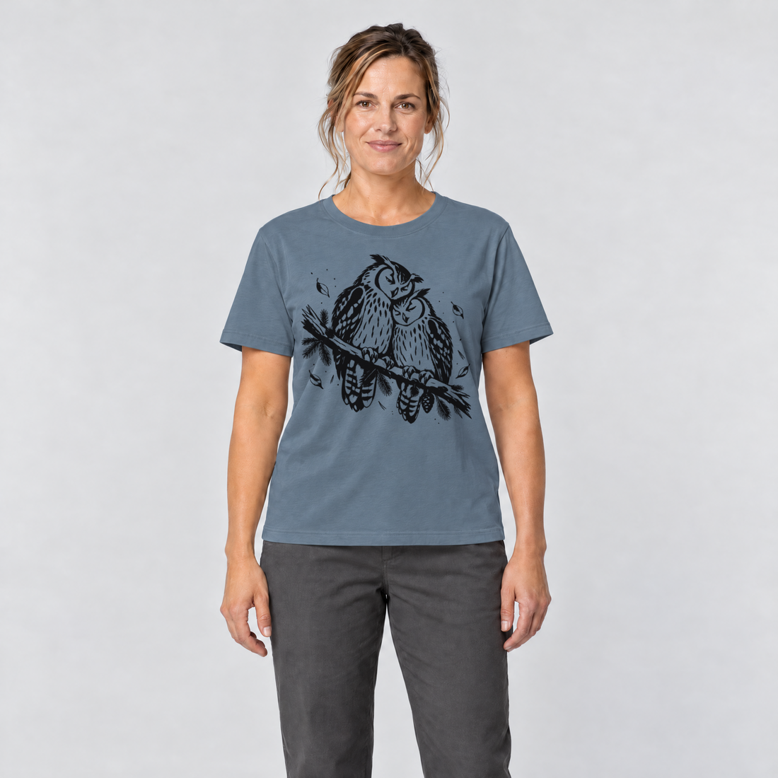 Frau trägt Uhupaar auf dem Fichtenast – T-Shirt Unisex in Steinblau, Ansicht von vorn