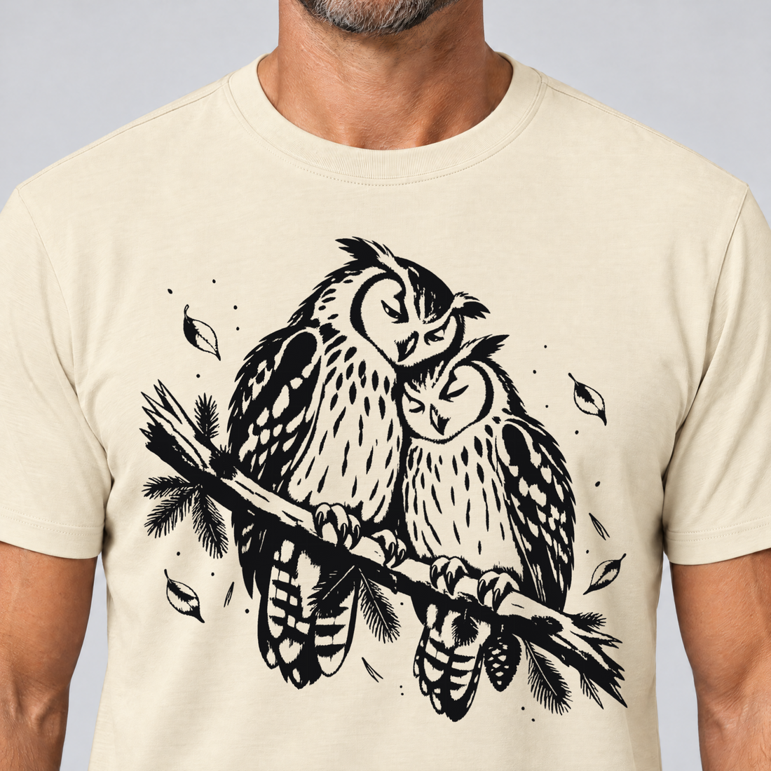 Nahaufnahme des Drucks: Uhupaar auf dem Fichtenast – T-Shirt Unisex in Natur, von einem Mann getragen