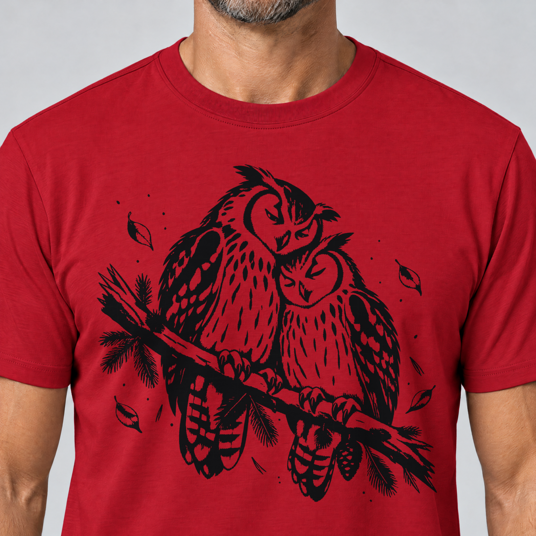 Nahaufnahme des Drucks: Uhupaar auf dem Fichtenast – T-Shirt Unisex in Rot, von einem Mann getragen