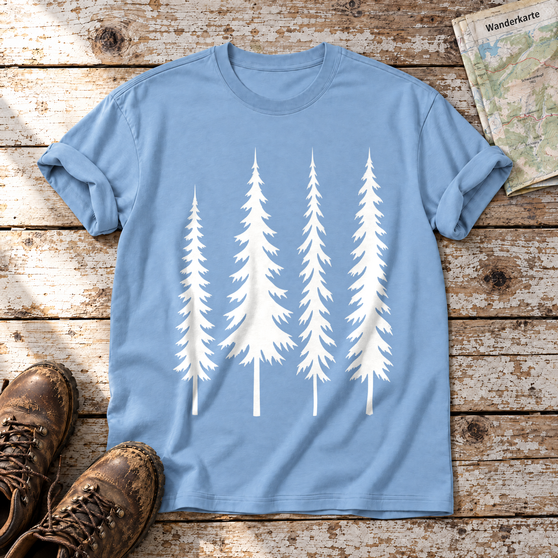 Vier Fichten – T-Shirt Unisex in Himmelblau, flach liegend auf alten Holzbrettern mit Wanderschuhen und Wanderkarte.