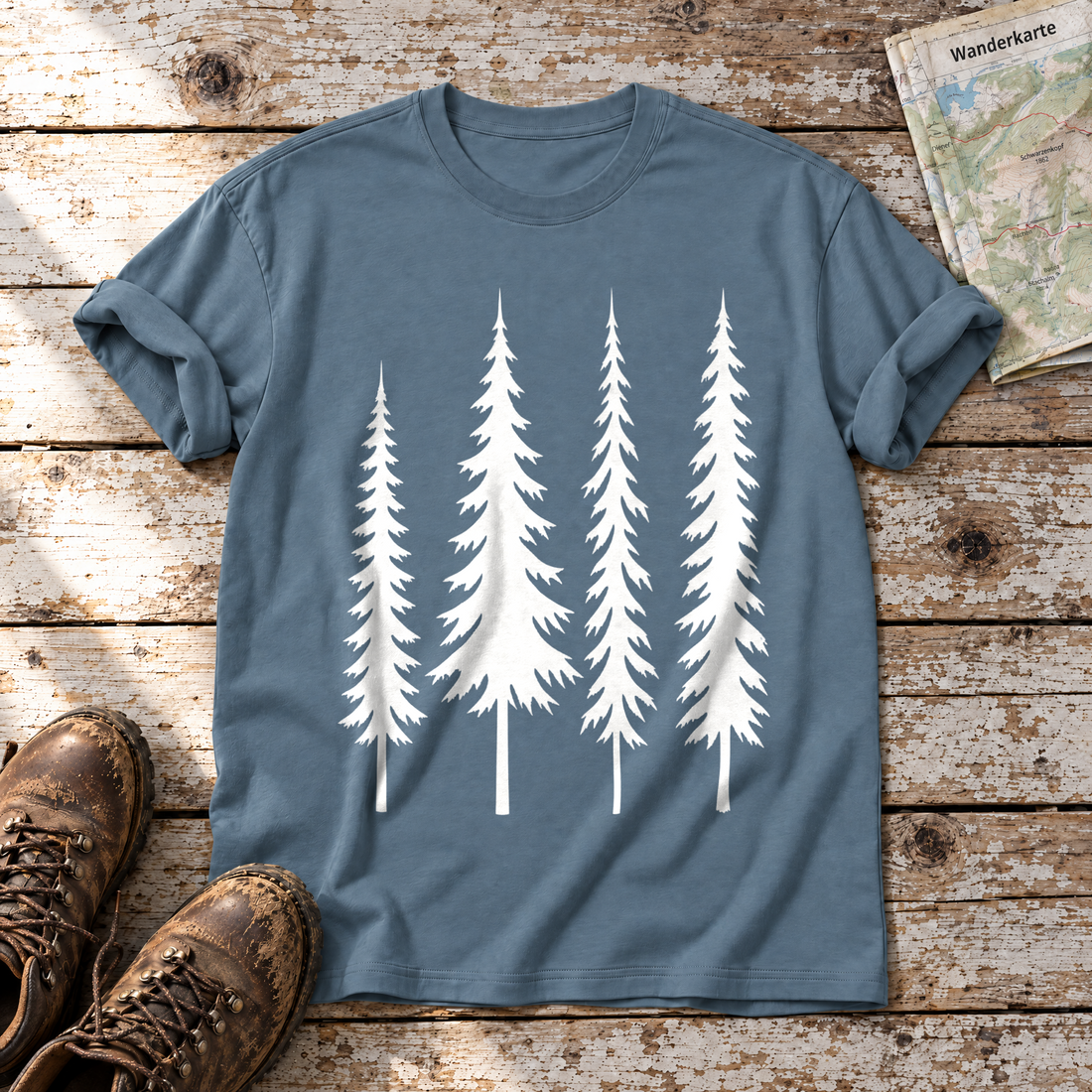 Vier Fichten – T-Shirt Unisex in Steinblau, flach liegend auf alten Holzbrettern mit Wanderschuhen und Wanderkarte.