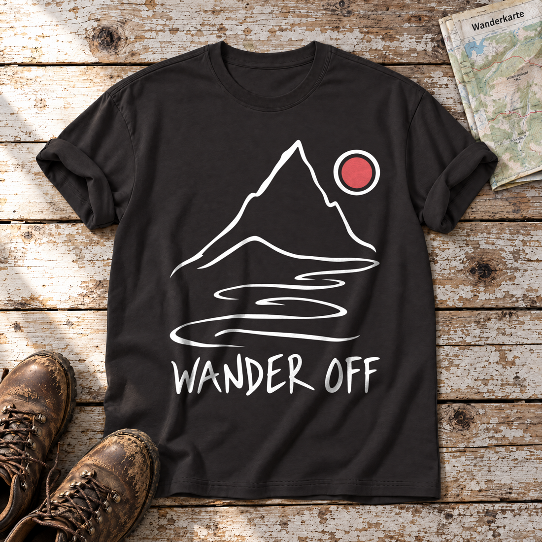 Wander off – T-Shirt Unisex in Schwarz, flach liegend auf alten Holzbrettern mit Wanderschuhen und Wanderkarte.