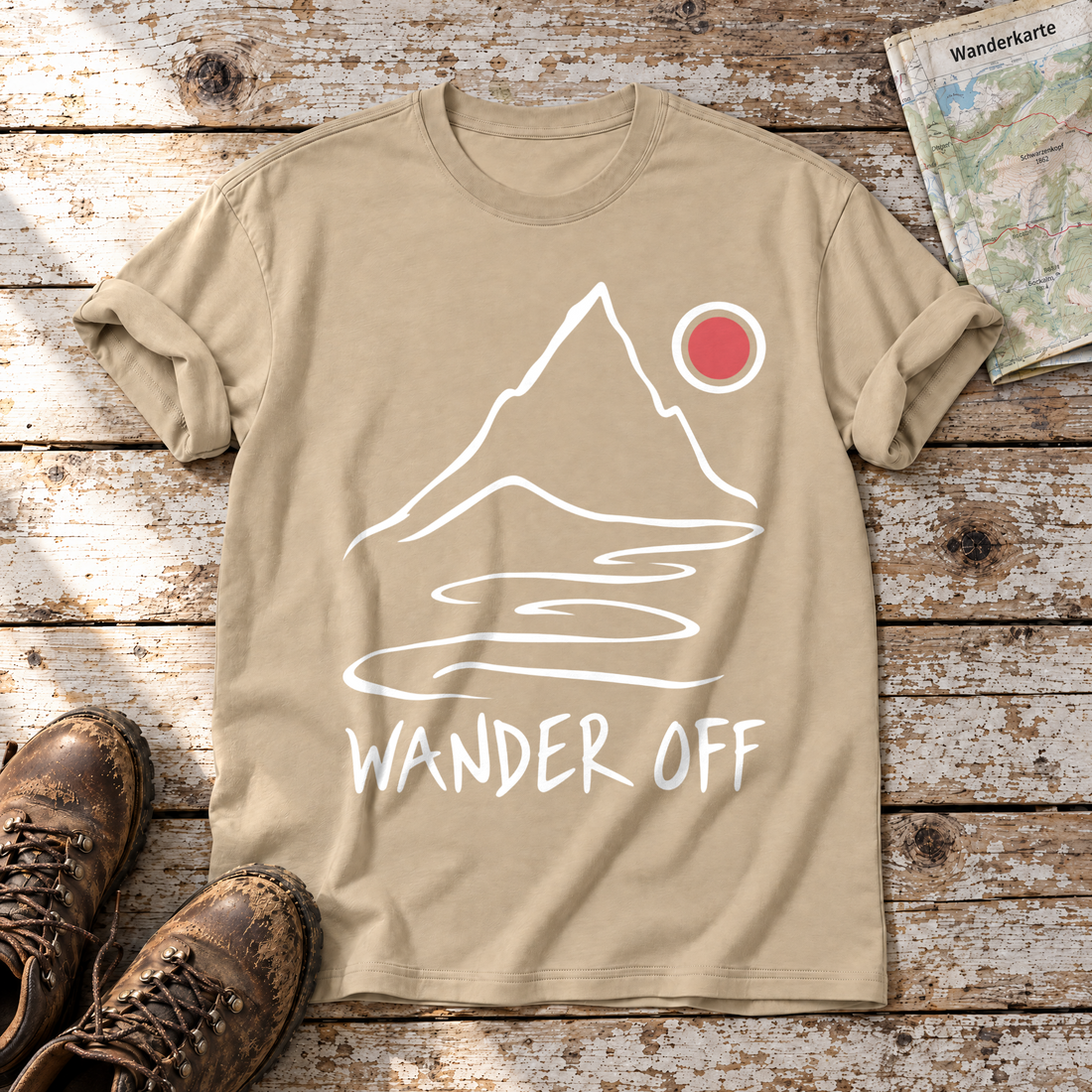 Wander off – T-Shirt Unisex in Sand, flach liegend auf alten Holzbrettern mit Wanderschuhen und Wanderkarte.