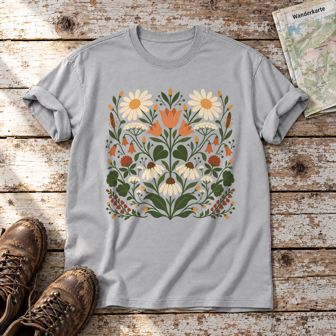 Wiesenblumenstrauß – T-Shirt Unisex in Hellgrau, flach liegend auf alten Holzbrettern mit Wanderschuhen und Wanderkarte.