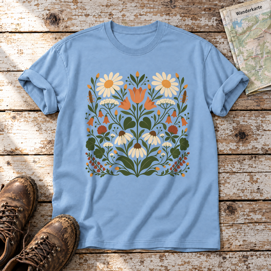 Wiesenblumenstrauß – T-Shirt Unisex in Himmelblau, flach liegend auf alten Holzbrettern mit Wanderschuhen und Wanderkarte.