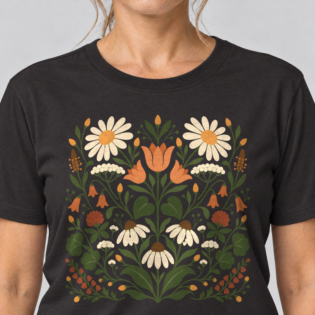 Nahaufnahme des Drucks: Wiesenblumenstrauß – T-Shirt Unisex in Schwarz, von einer Frau getragen