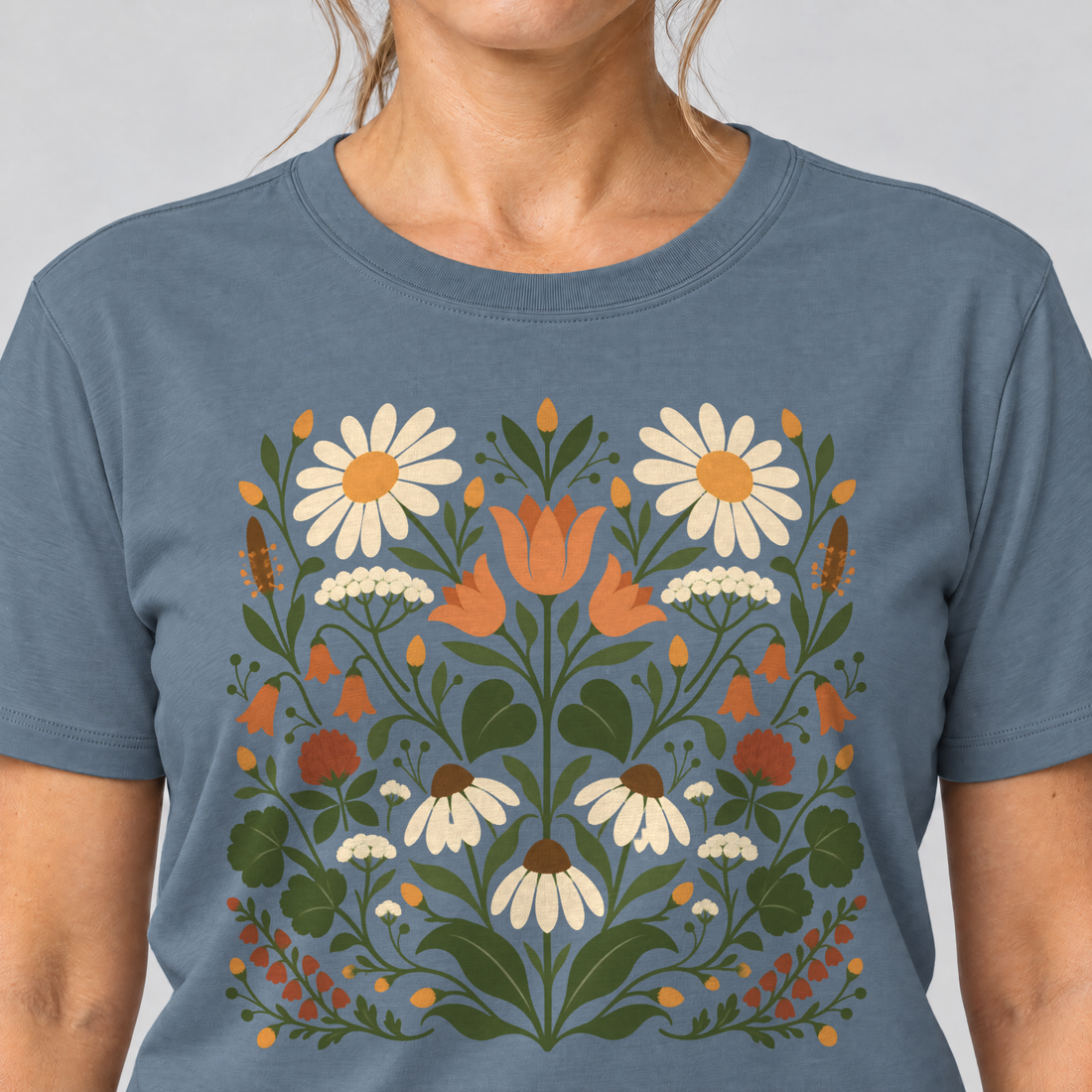 Nahaufnahme des Drucks: Wiesenblumenstrauß – T-Shirt Unisex in Steinblau, von einer Frau getragen