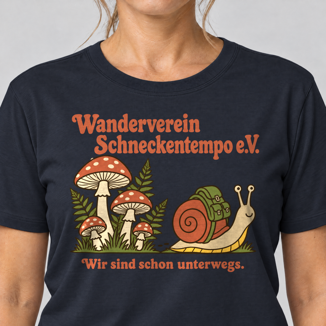 Nahaufnahme des Drucks: Wanderverein Schneckentempo – T-Shirt Unisex in Navy, von einer Frau getragen