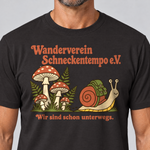 Nahaufnahme des Drucks: Wanderverein Schneckentempo – T-Shirt Unisex in Schwarz, von einem Mann getragen